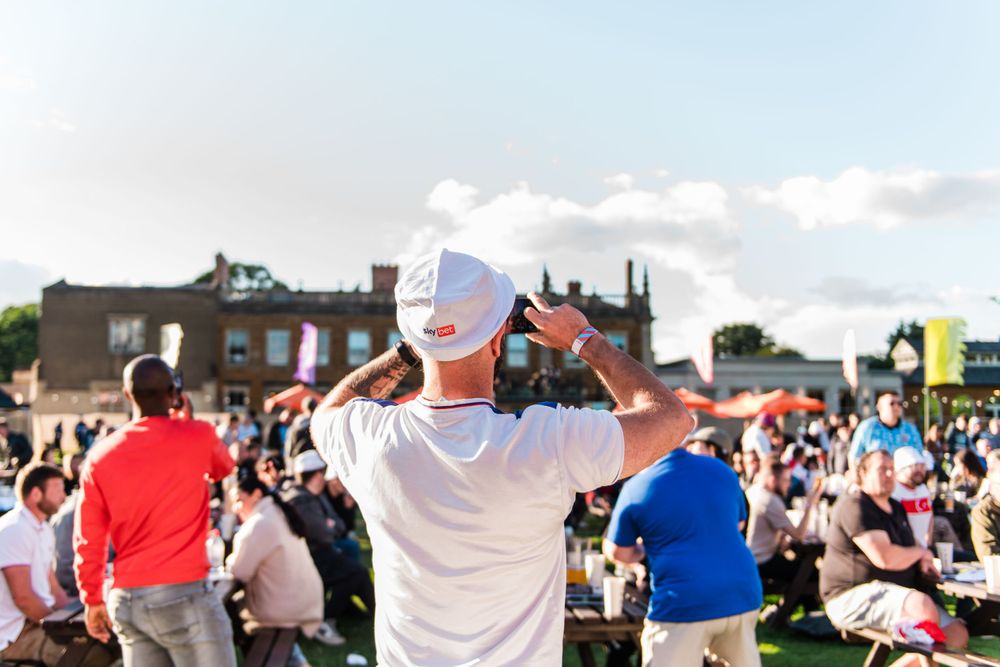 A large crowd of people gathered outdoors for a sporting event or festival on a sunny day.