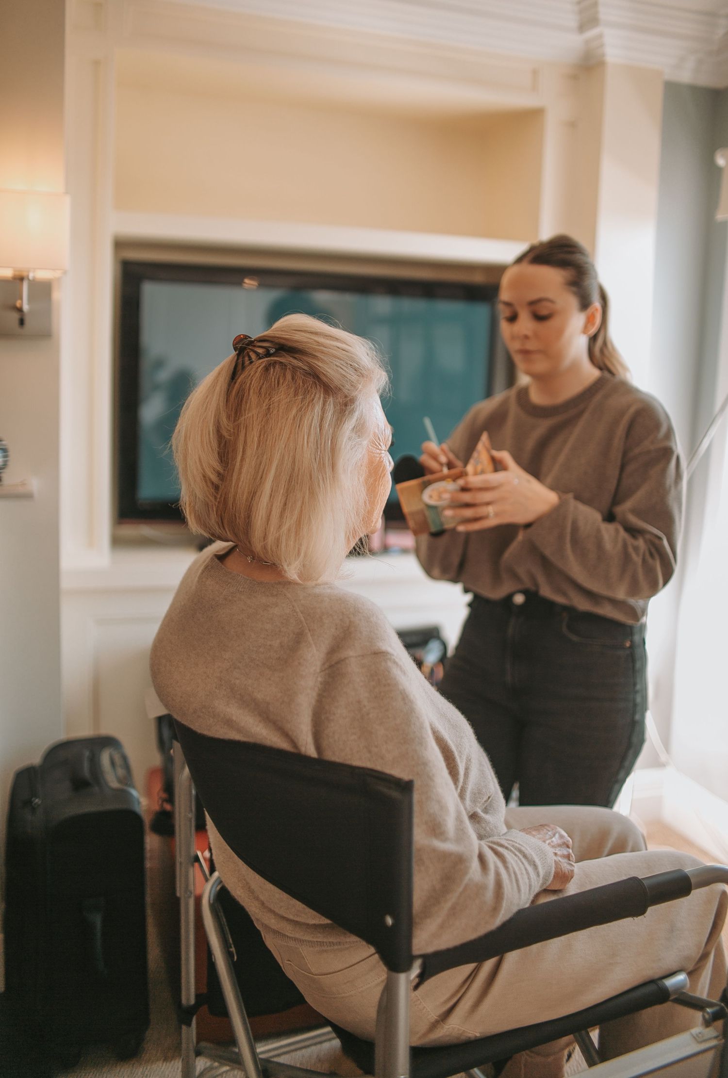 Wedding preparation scene showing styling session in a bright indoor setting.