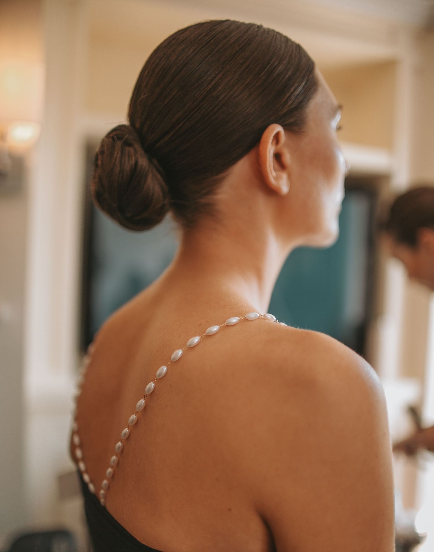 Elegant updo hairstyle with pearl details captured from behind.