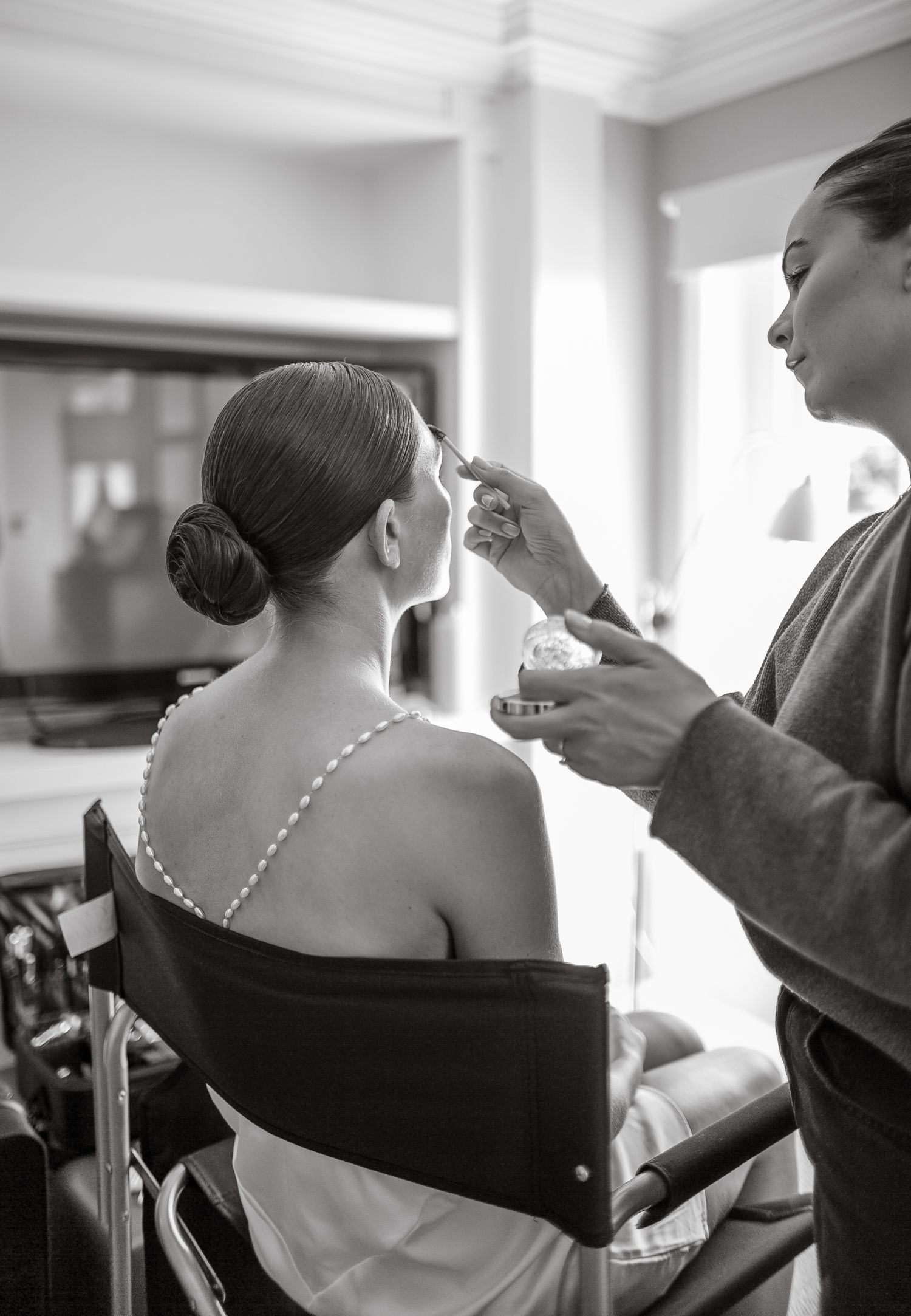 Black and white photo of wedding day preparation showing hair styling.