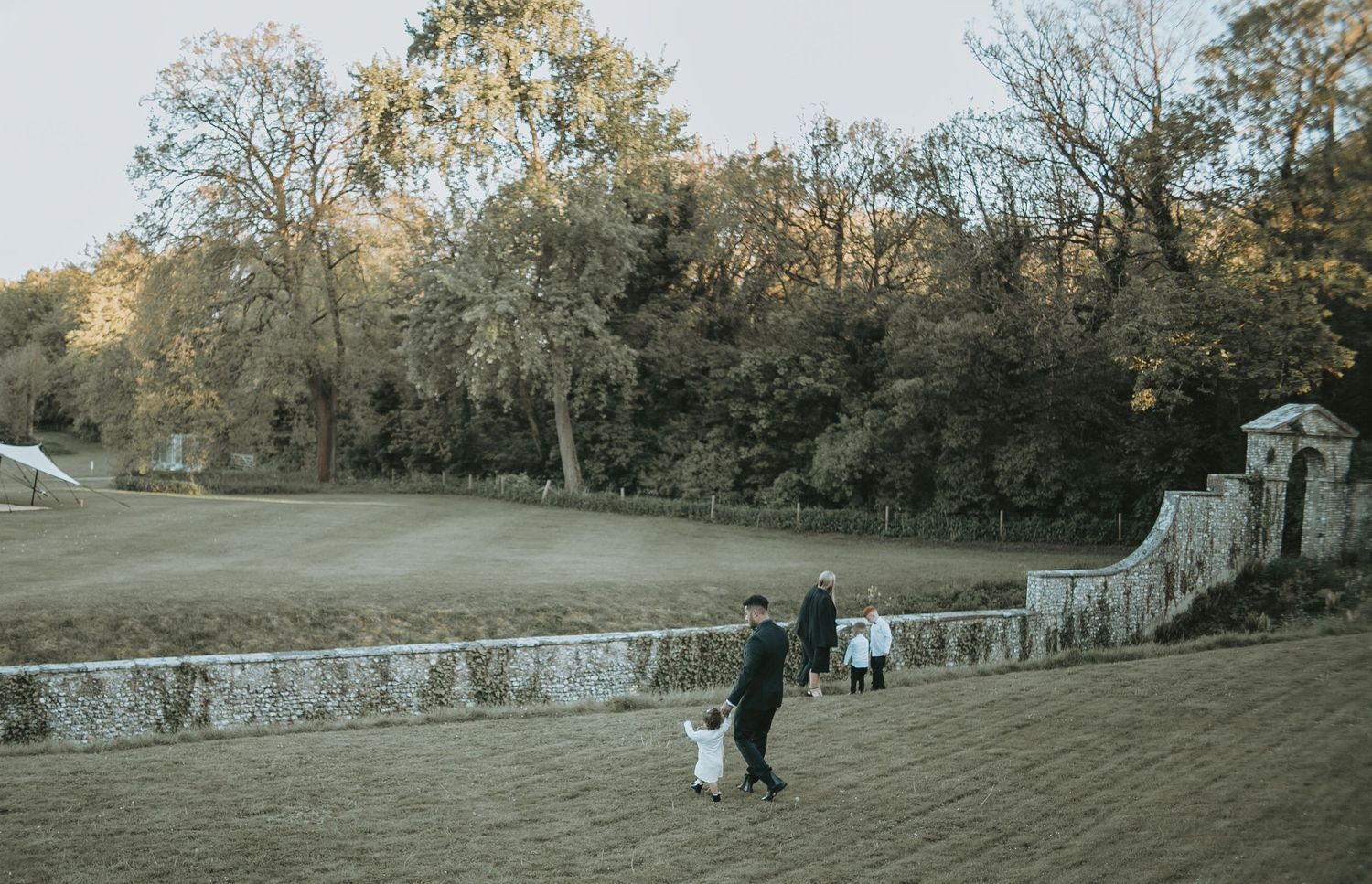 A panoramic view of a historic stone building and grounds during golden hour.