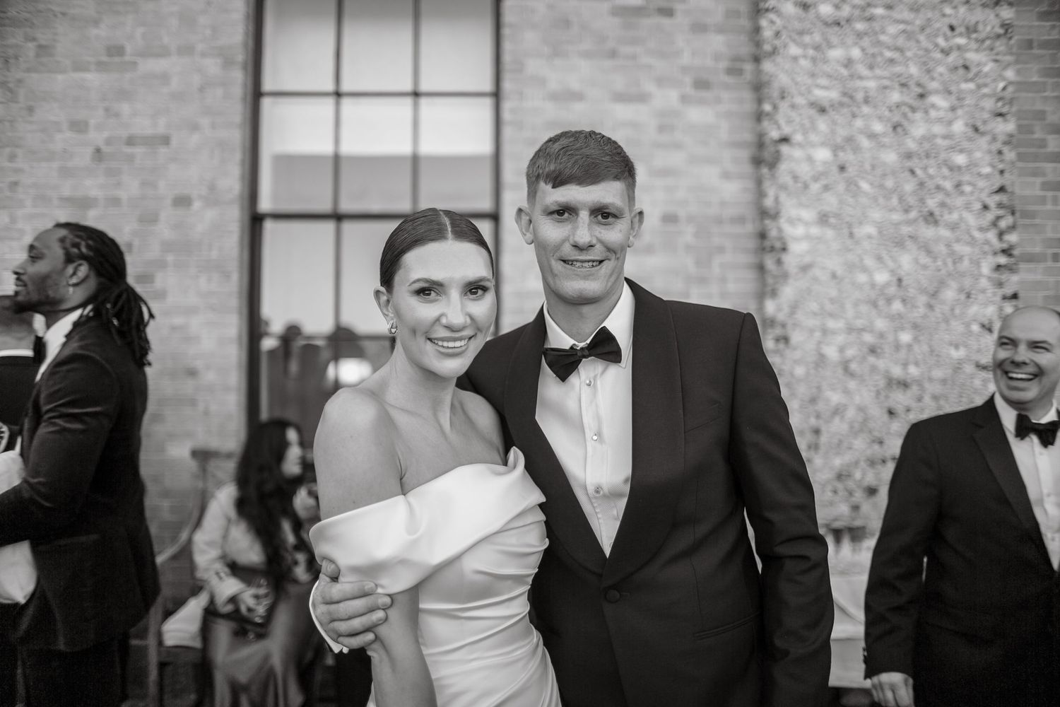 Guests mingling at an elegant outdoor wedding reception near a stone building.