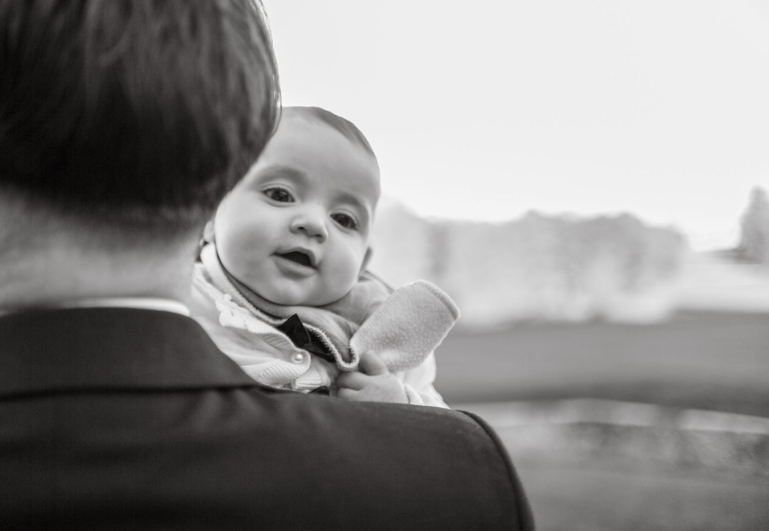 Black and white images of a baby being held during a wedding celebration.