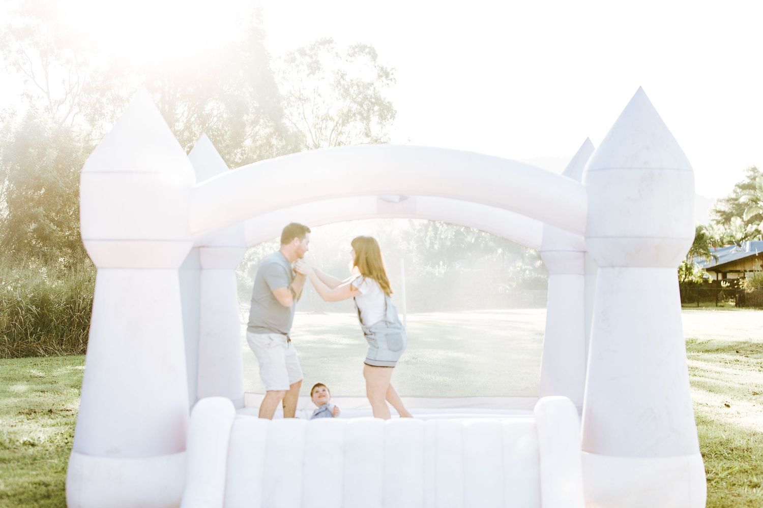 Sunlit moment captured in a white inflatable bounce house during golden hour.
