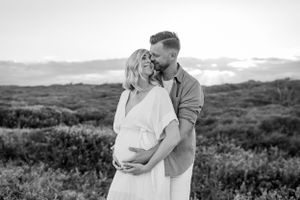 Black and white intimate maternity portrait in natural setting.