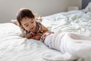Sweet moment of connection on soft white bedding.
