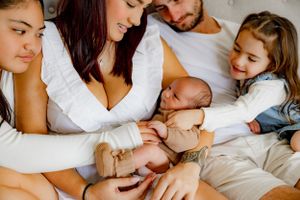 Candid family moment captured with newborn during indoor lifestyle photoshoot.
