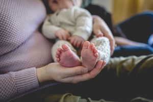 Close-up of tiny baby feet being held in gentle hands.