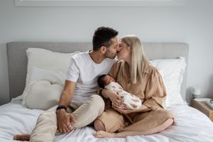 Intimate moment captured in a bright, modern bedroom with neutral decor.