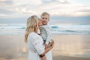 An intimate moment shared between two people on a beach at sunset.