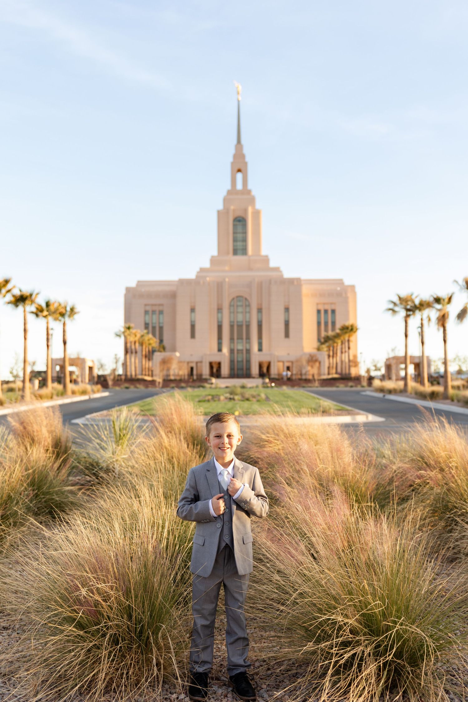 boy standing in a field of yellow tall grass with the temple in the background