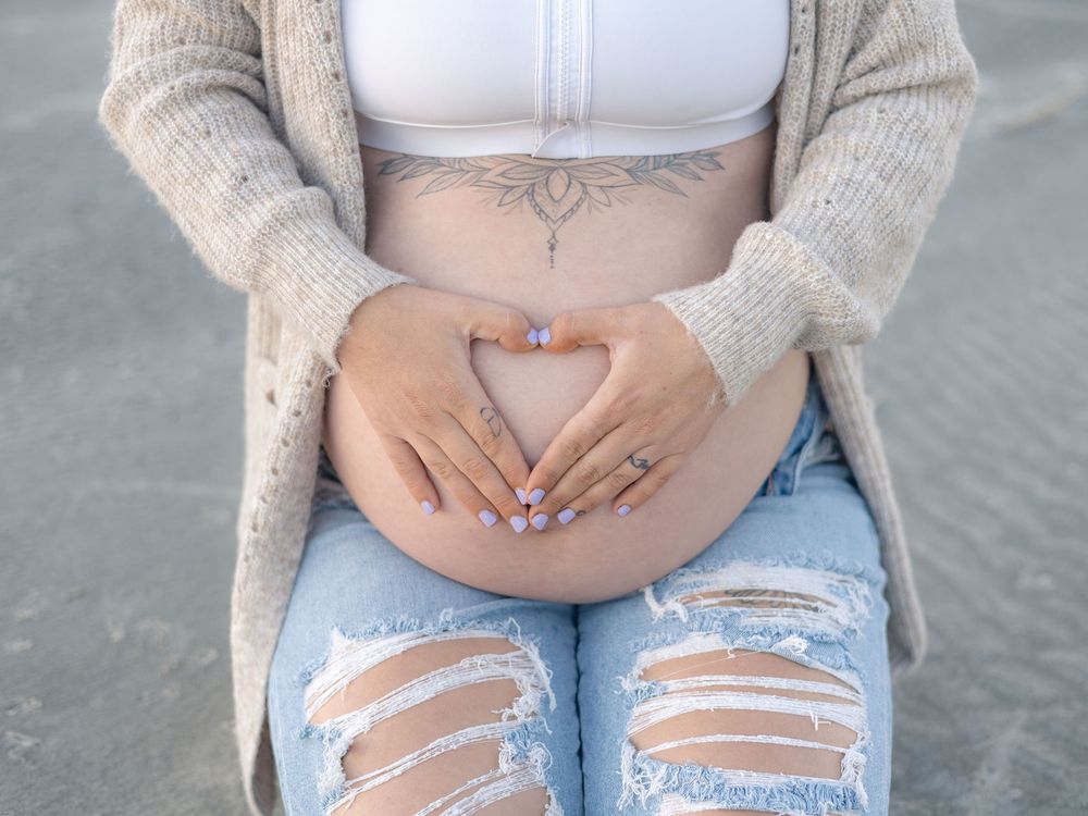 Close-up view of distressed light blue denim jeans with ripped knees and a cozy beige knit cardigan.