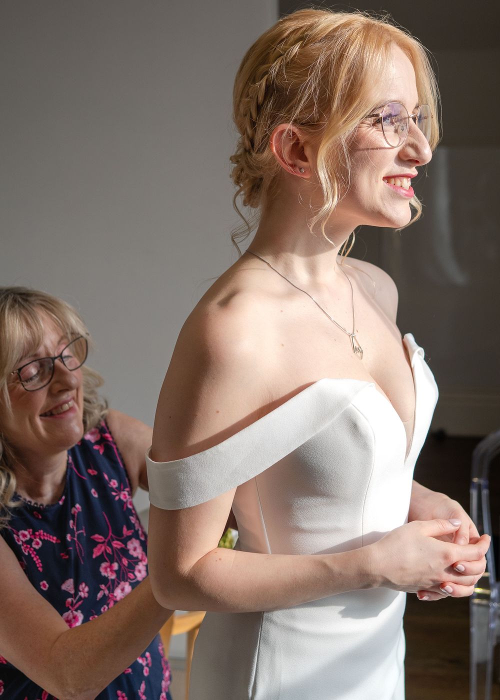 Sheffield Town Hall Wedding - Close-up of person in white off-shoulder wedding dress getting ready.