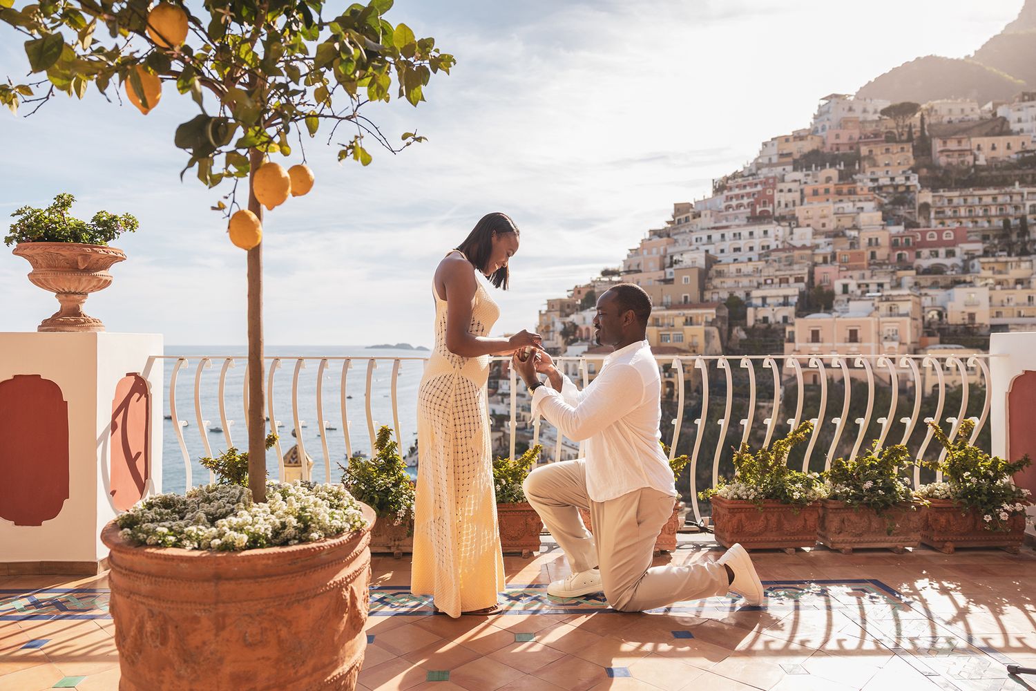 Romantic marriage proposal overlooking the scenic Amalfi Coast in Italy with historic buildings and Mediterranean Sea views.