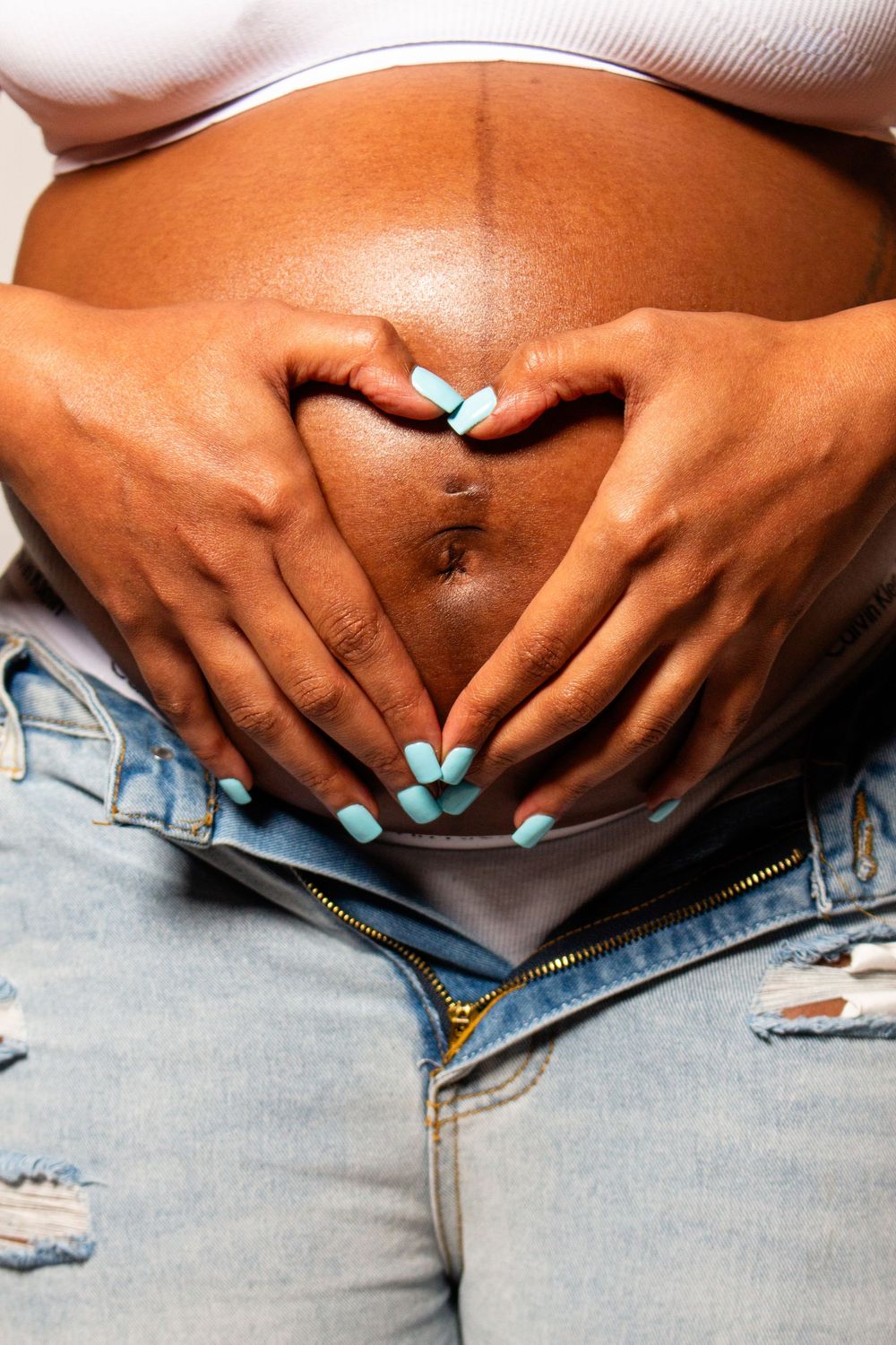 "Close-up of a maternity photo highlighting baby bump and hands"