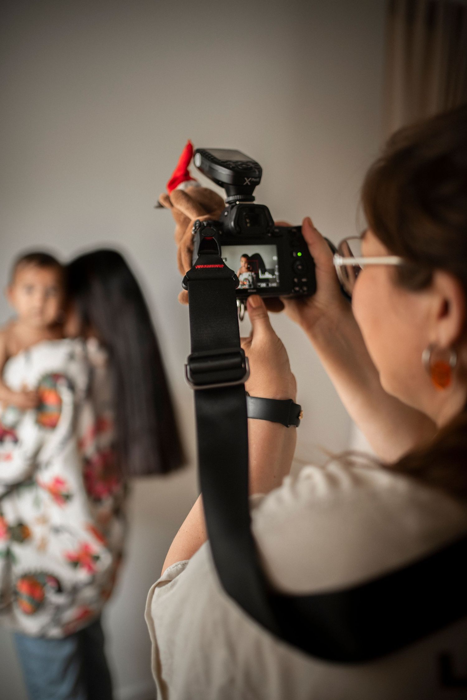 Four sequential images showing the behind view of someone taking photos with a camera wearing a floral patterned shirt.
