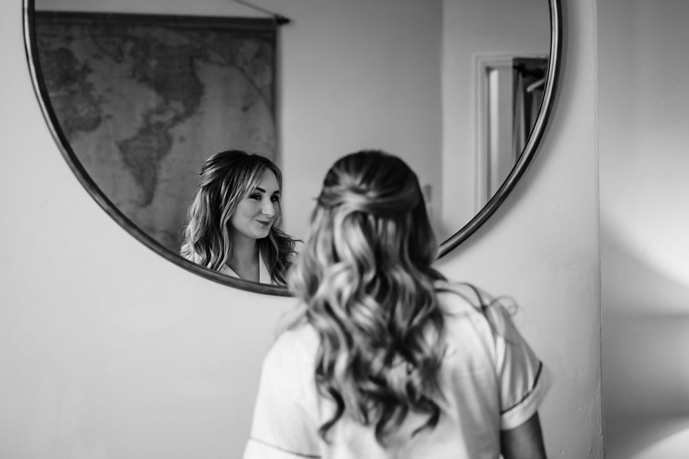 Black and white photo sequence shows a couple sharing intimate moments and laughter in front of circular mirrors.