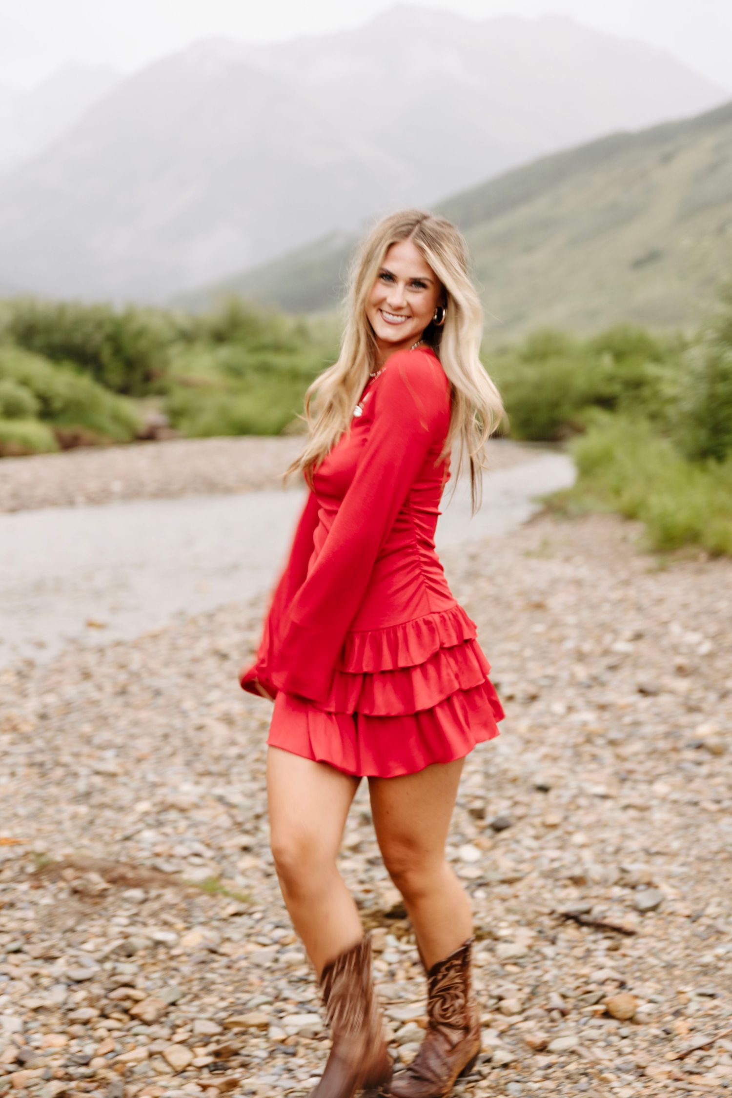 A beautiful senior girl in a red dress posing for her photos for her senior photoshoot with Kelly Elizabeth Photography