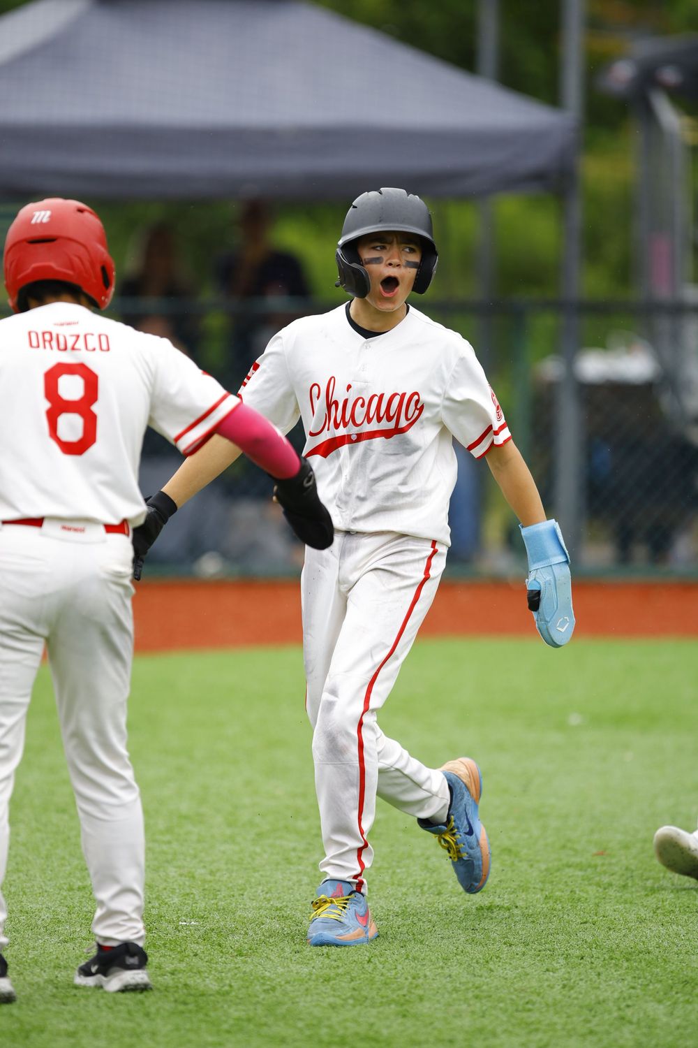 Baseball players celebrate on field wearing Chicago uniforms during game.