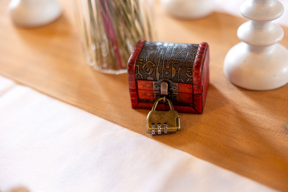 Small decorative wooden treasure chest with key on wooden table.