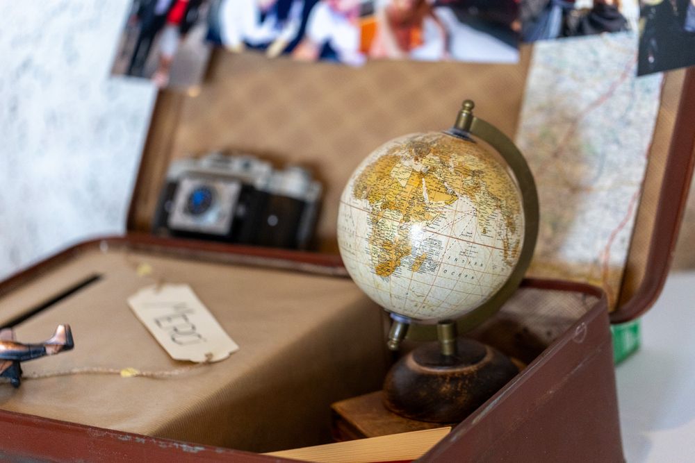 Decorative globe inside vintage suitcase with travel-themed wedding memorabilia.