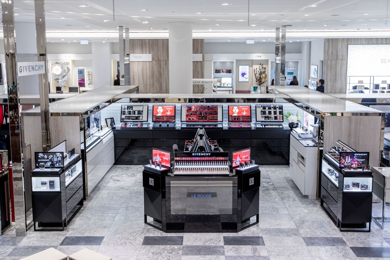 Modern retail electronics display setup with digital screens and counters in a department store.