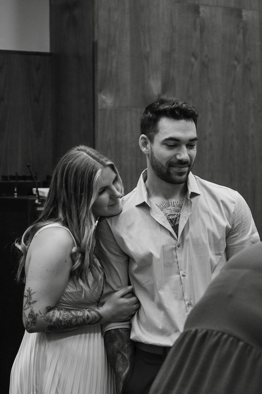 A black and white photo captures a tender moment between newlyweds at their courthouse ceremony.