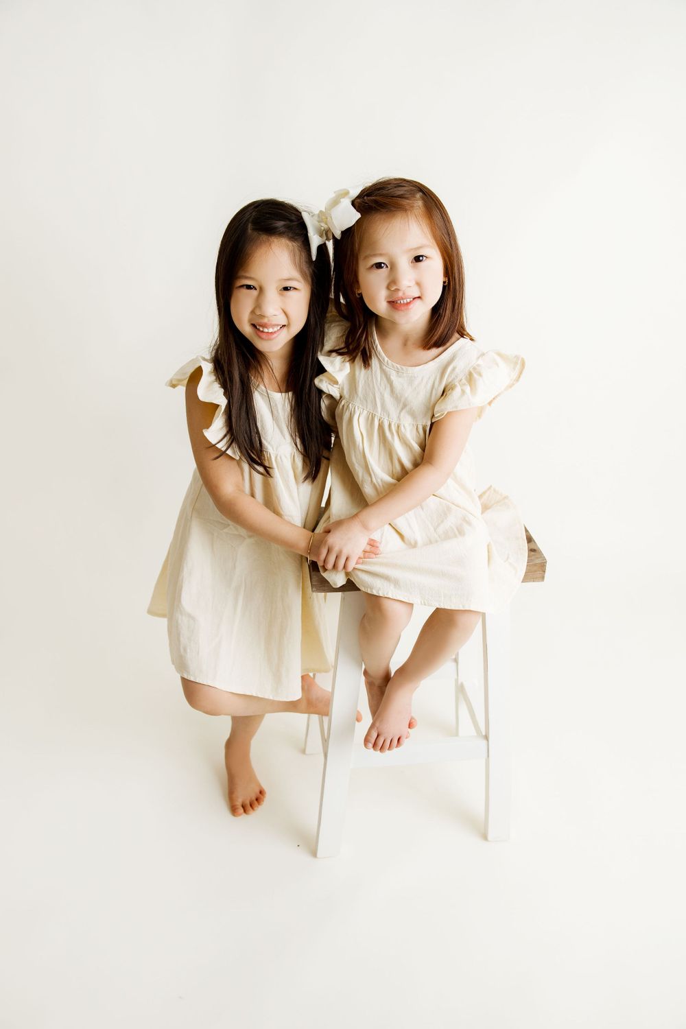 Two girls sibling pose during a family studio session