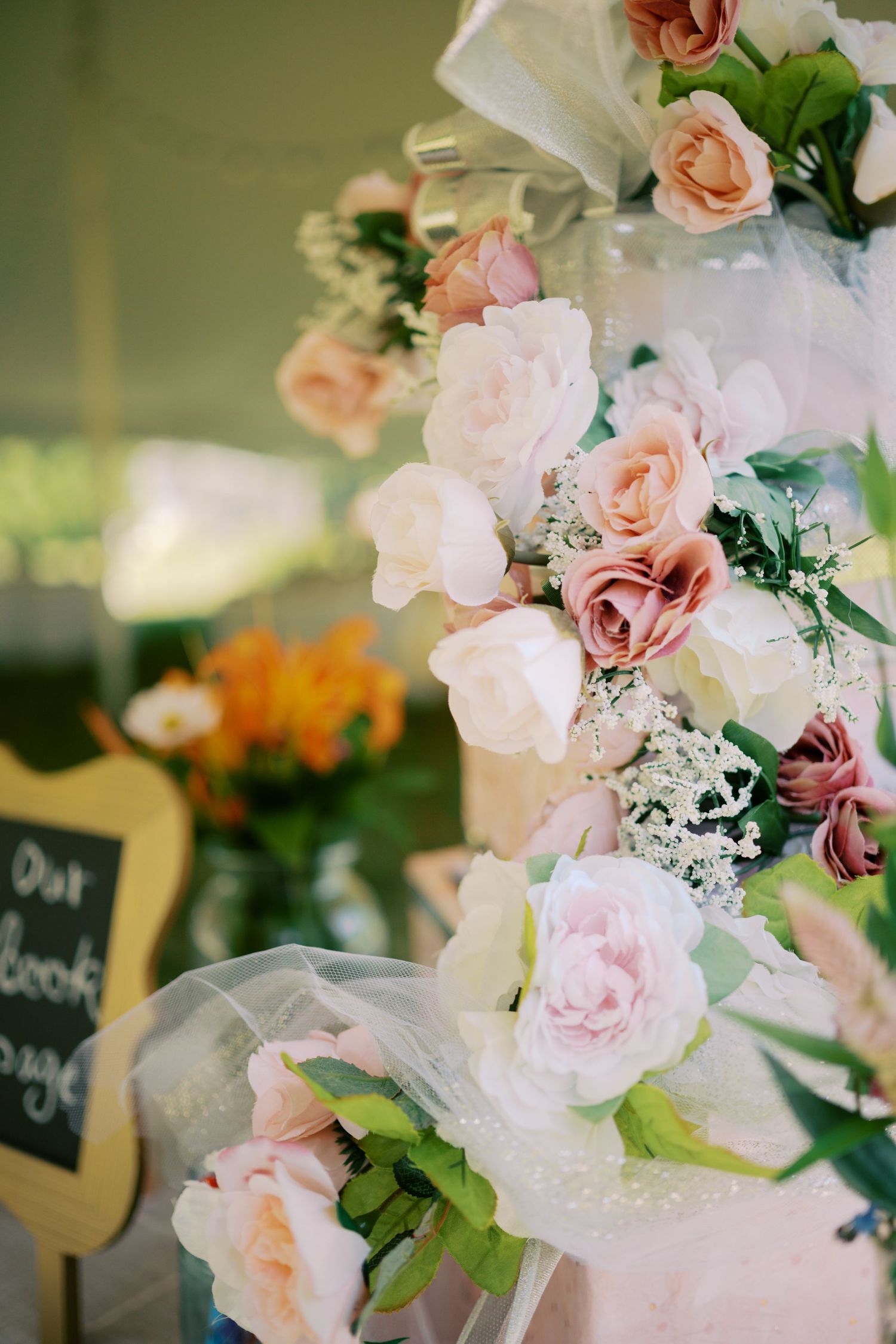 Delicate pink and peach roses arranged with baby's breath and greenery create a romantic wedding floral display.