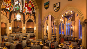 Panoramic view of an elegant restaurant interior with arched windows, vintage decor and warm lighting creating an inviting ambiance.