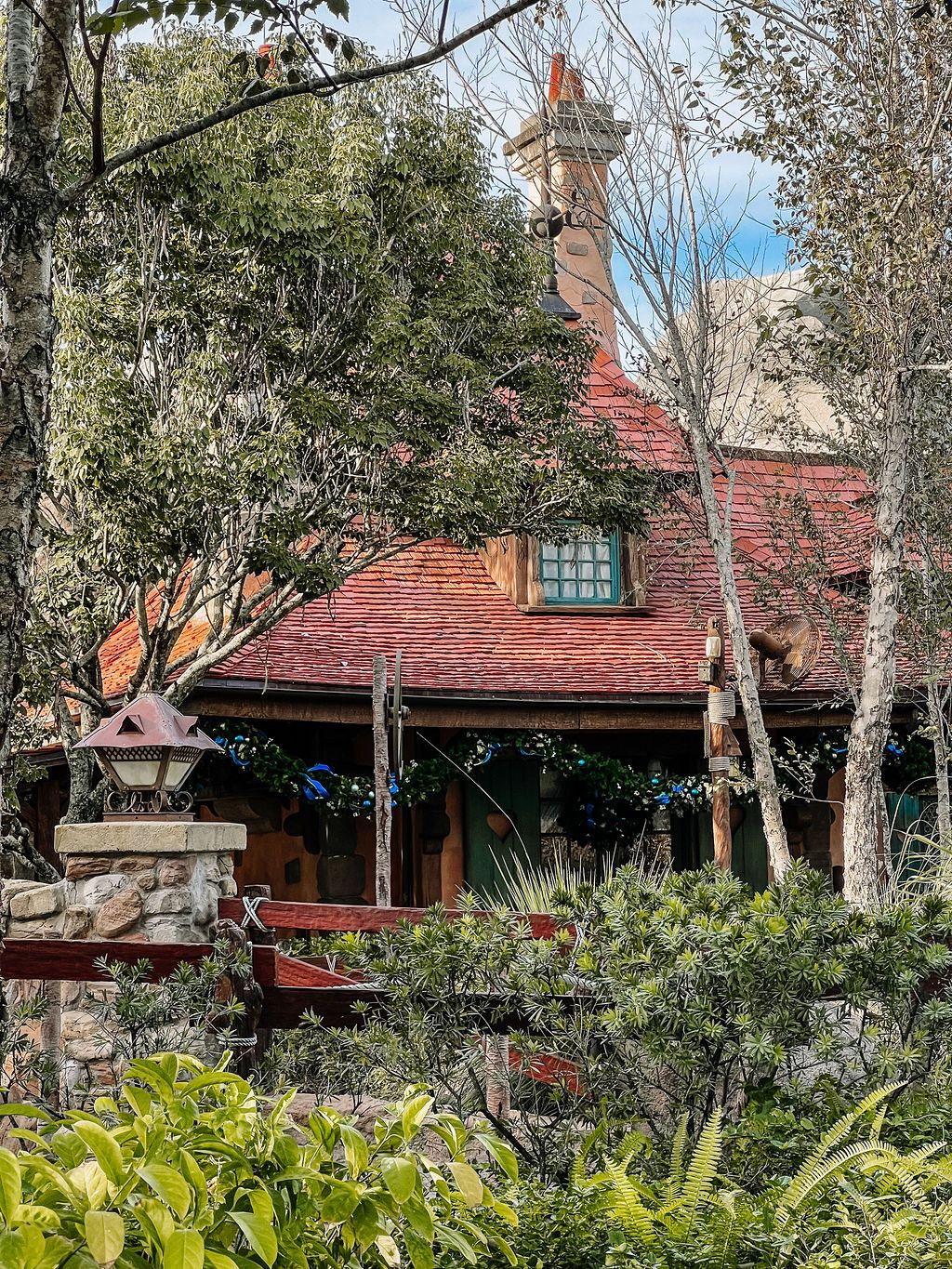 Magic Kingdom's signature red-roofed Fantasyland buildings surrounded by lush greenery and trees at Walt Disney World.