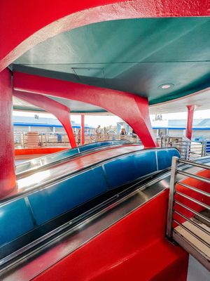 Abstract panoramic view of a red and blue-tinted bowling alley interior with curved architectural elements.
