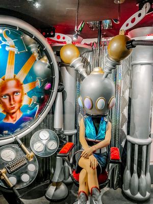 A retro-futuristic sci-fi themed display featuring robot sculptures, metallic pipes, and colorful decorative elements.