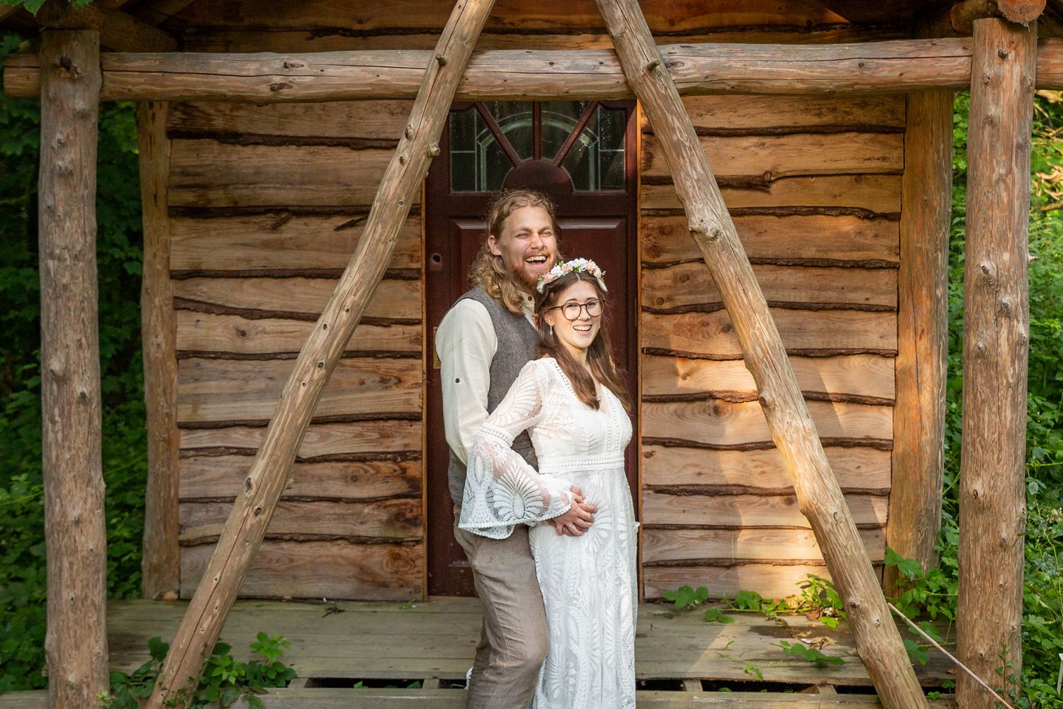 North Wales Alternative Wedding Photographer. Portrait of a bride and groom by a woodland cabin. Woodland Wedding. Handfasting.