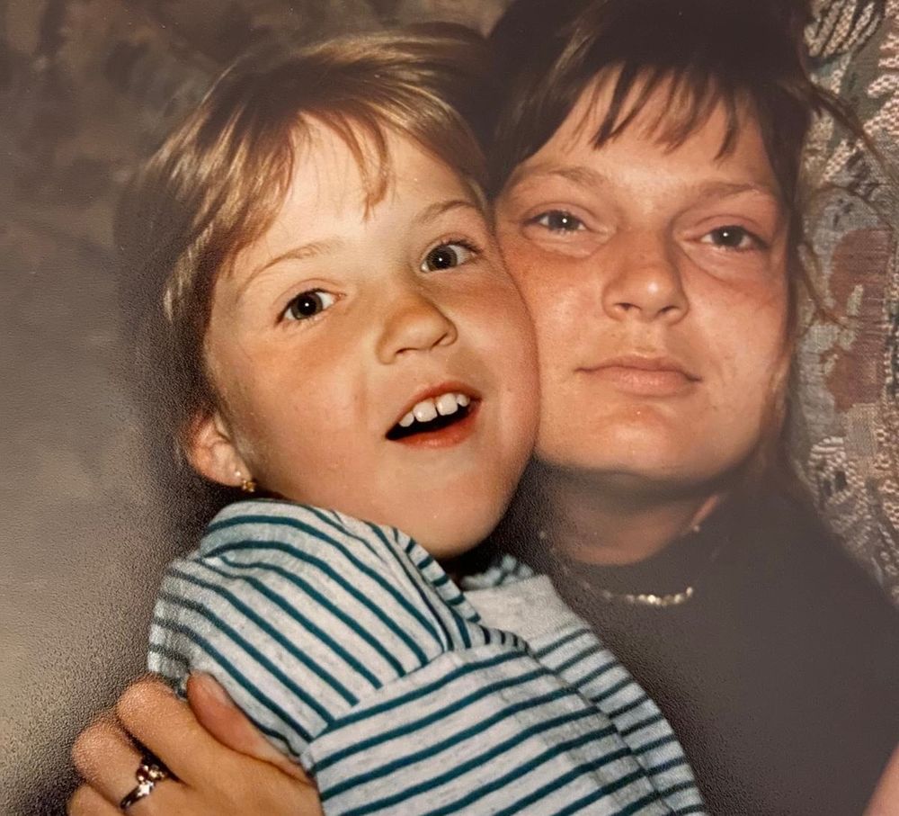 Vintage photo of a smiling young child with a woman, likely mother and child portrait from the 1980s.