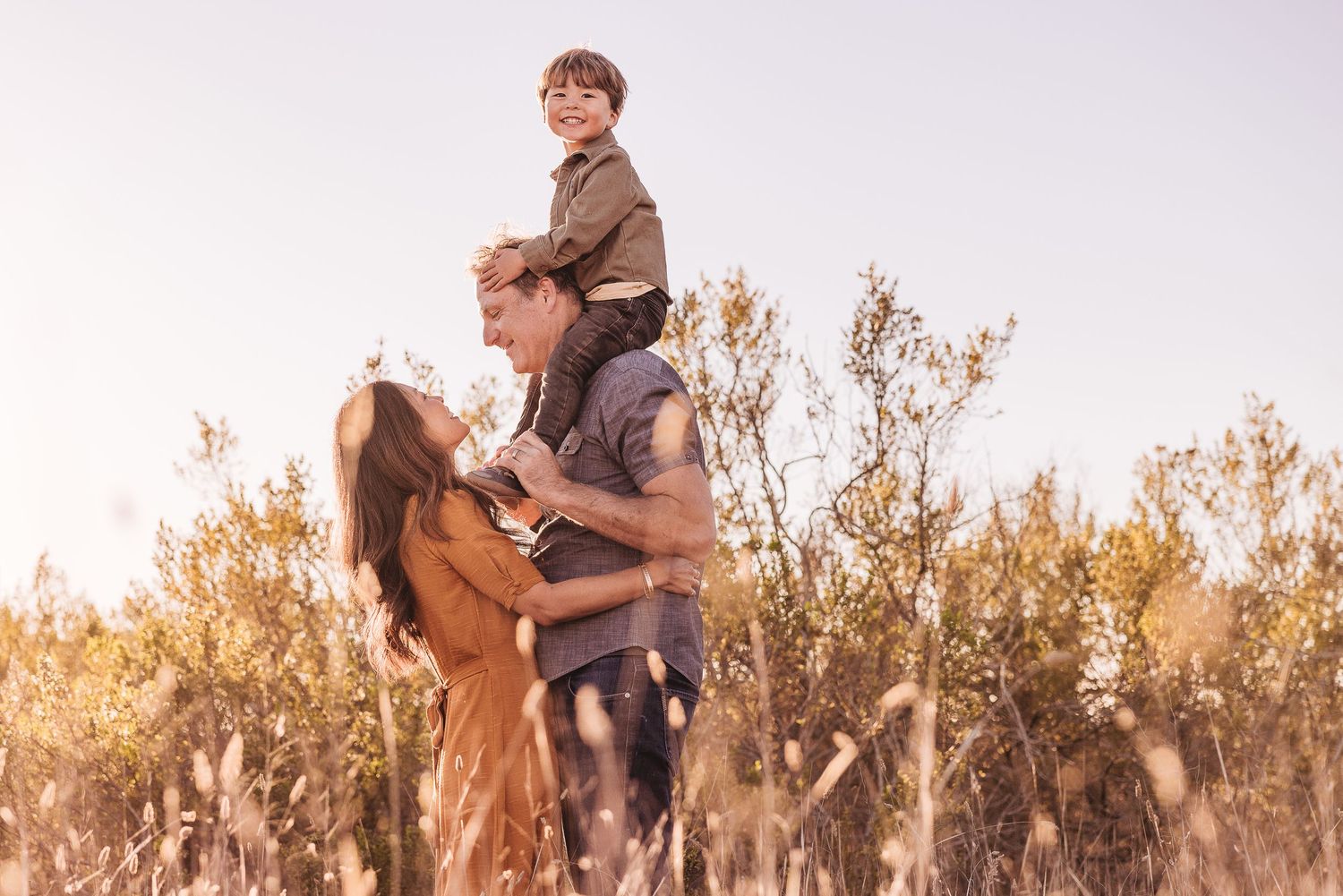 Family enjoying a field during professional photography session. what to wear for family session in foothills.