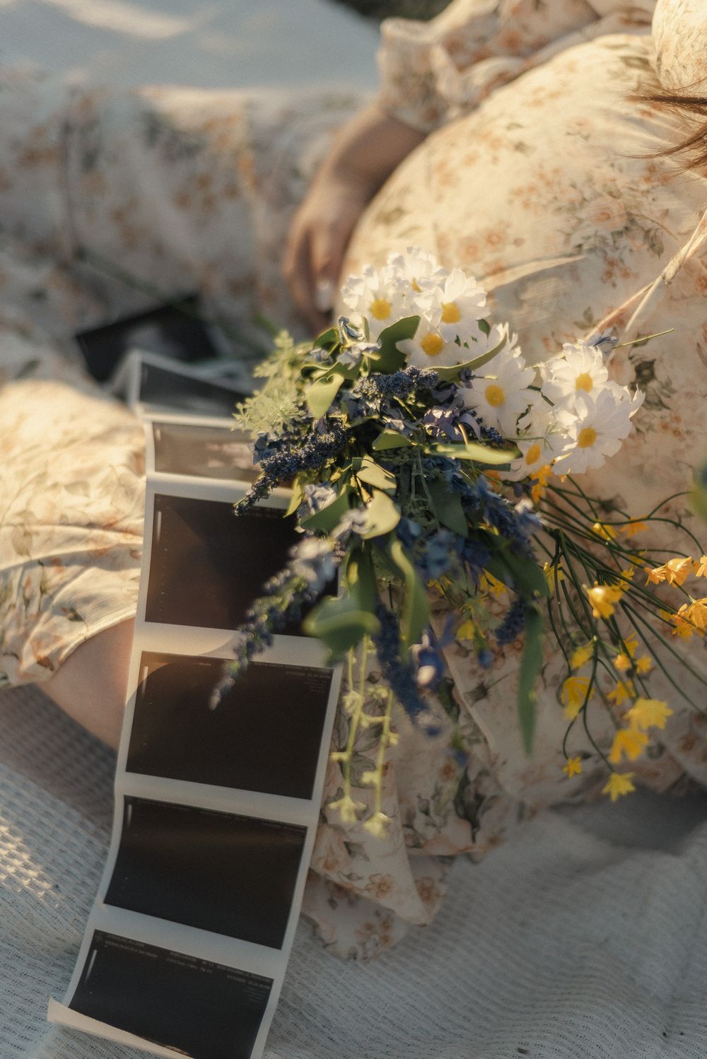 Lifestyle maternity detail with flowers and ultrasound during cozy outdoor session in Central Texas