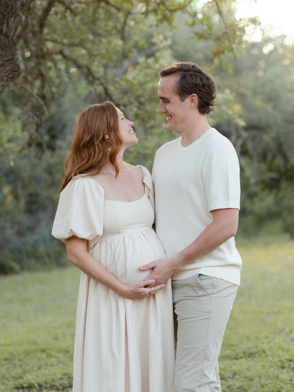 Expecting couple holding baby bump together during outdoor maternity session in Central Texas