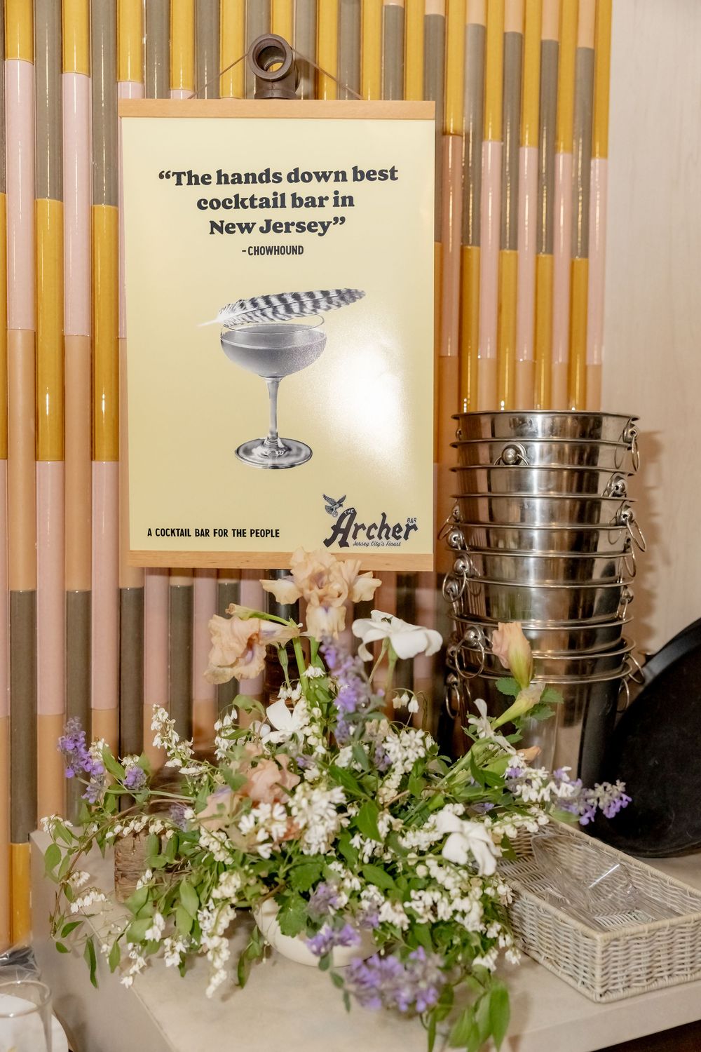 Archer cocktail bar sign with floral arrangement and stacked ice buckets at New Jersey's best cocktail bar.