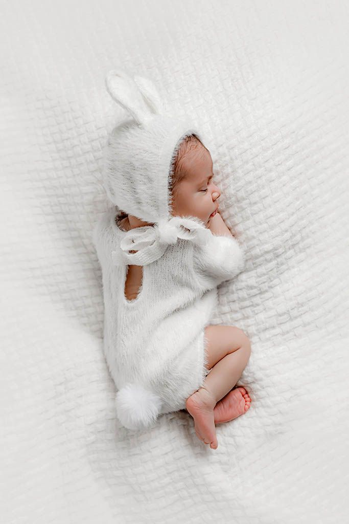 Newborn baby sleeping peacefully in white Easter bunny outfit - Winchester CA newborn photography.