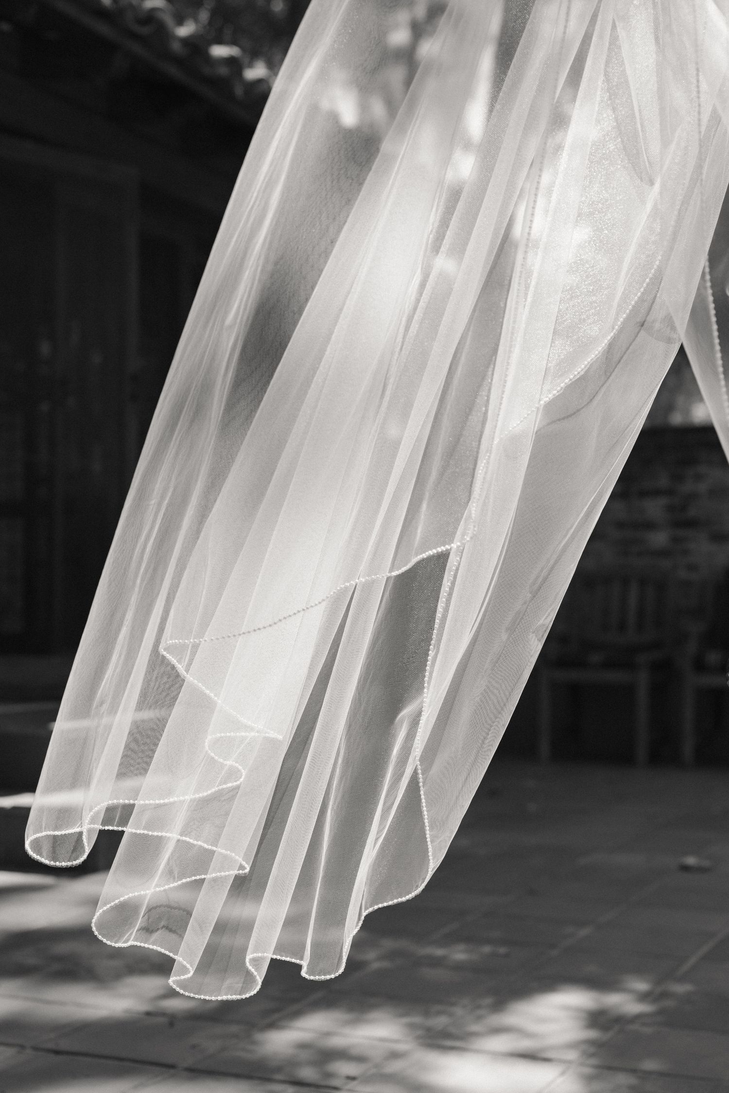 Flowing white bridal veil captured in black and white, billowing gracefully in the breeze.