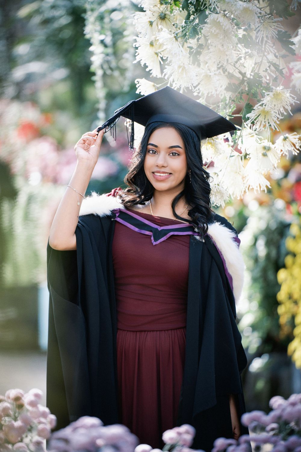 Auckland graduation photographer portfolio. Stunning outdoor University of Auckland graduation portrait of a student among blooming flowers