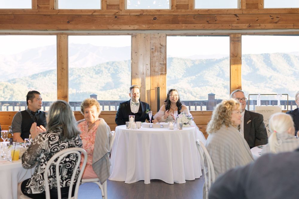 Guests gathered at elegant mountain view venue for a formal panel discussion during a special event or wedding reception.