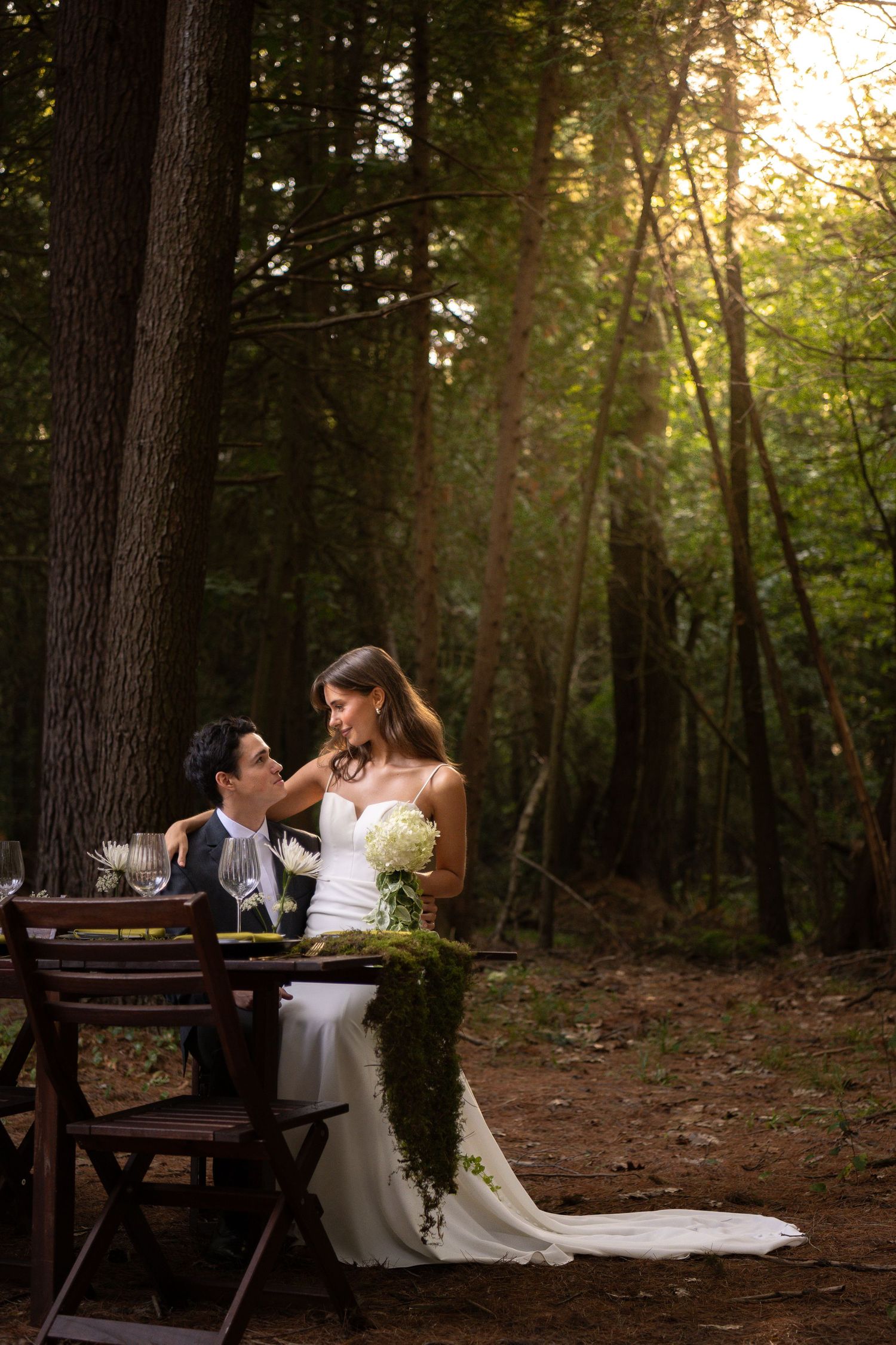 Bride and groom embracing and kissing in front of a grand wooden door entrance of the Royal venue.