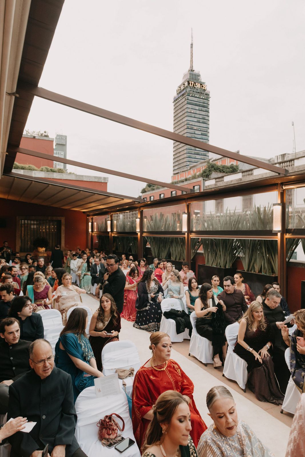 Guests seated on a rooftop terrace venue with Torre Latinoamericana skyscraper in background during an outdoor event.