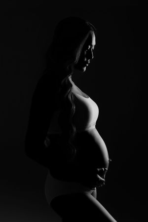 Artistic black and white silhouette of pregnant figure.