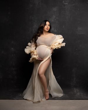 Ethereal maternity portrait in cream pleated gown with ruffled details.