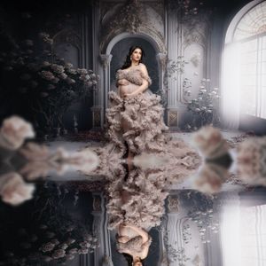 Dreamy maternity portrait in champagne gown with mirror reflection in ornate architectural setting.