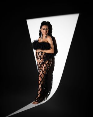 Artistic black and white portrait with geometric lighting and latticed gown.