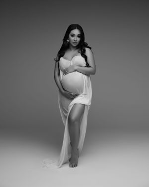 Black and white maternity portrait in simple white flowing dress.
